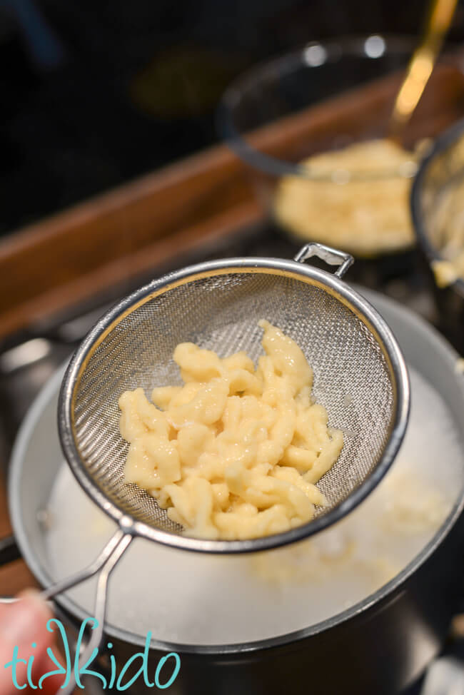 German spaetzle being removed from boiling water.