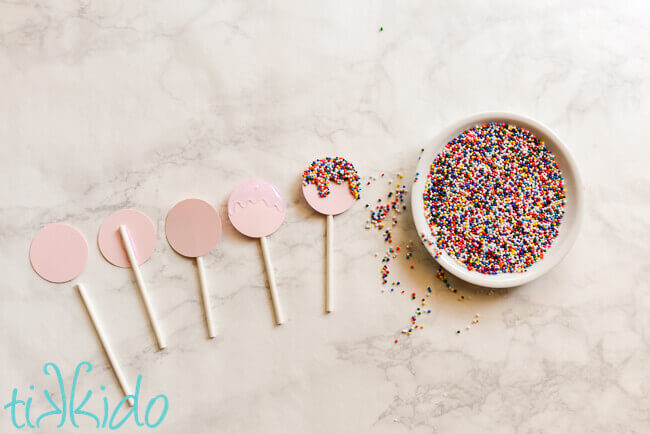 Progress pictures of making the paper lollipops covered with sprinkles.