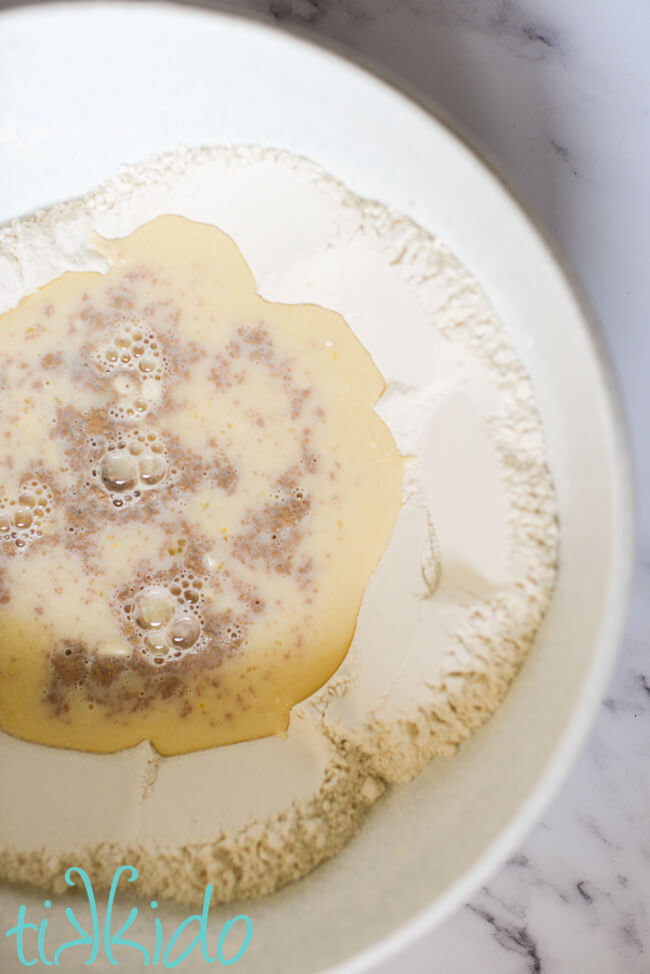 Ingredients for sticky bun dough in a large mixing bowl.