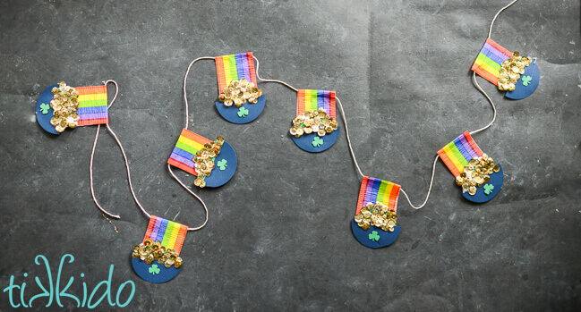 Pot of Gold and rainbow St Patrick's Day garland on a black chalkboard background.