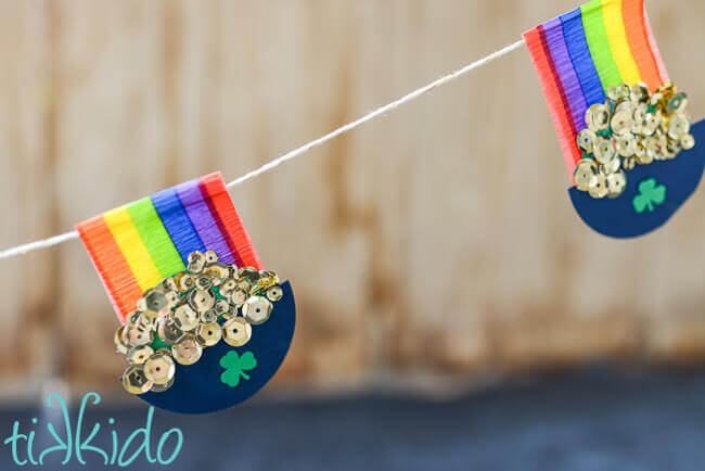 Rainbow and Pot of Gold garland hung in front of a brown wooden backdrop.