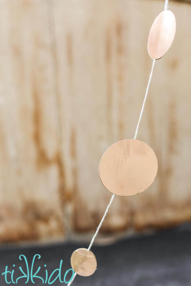 Gold Circle garland hung in front of a wooden background