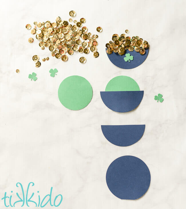 Process of assembling round circles of cardstock together and enhancing with gold sequins to create pots of gold.