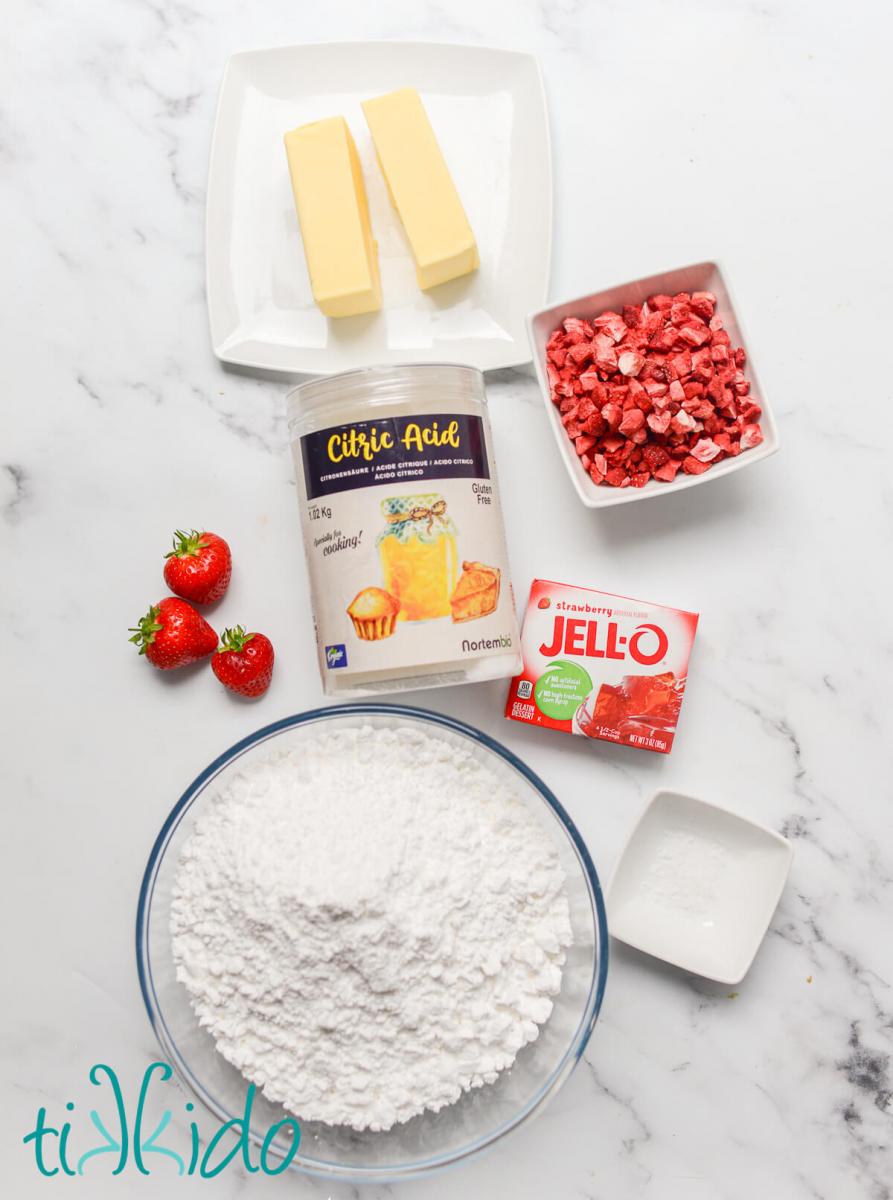 Ingredients for the best strawberry frosting recipe on a marble surface.