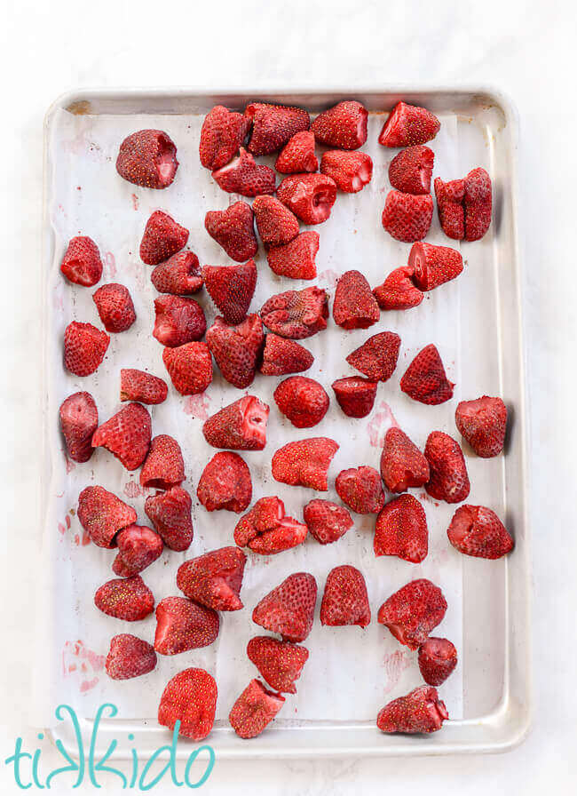 Frozen hulled strawberries on a sheet pan.