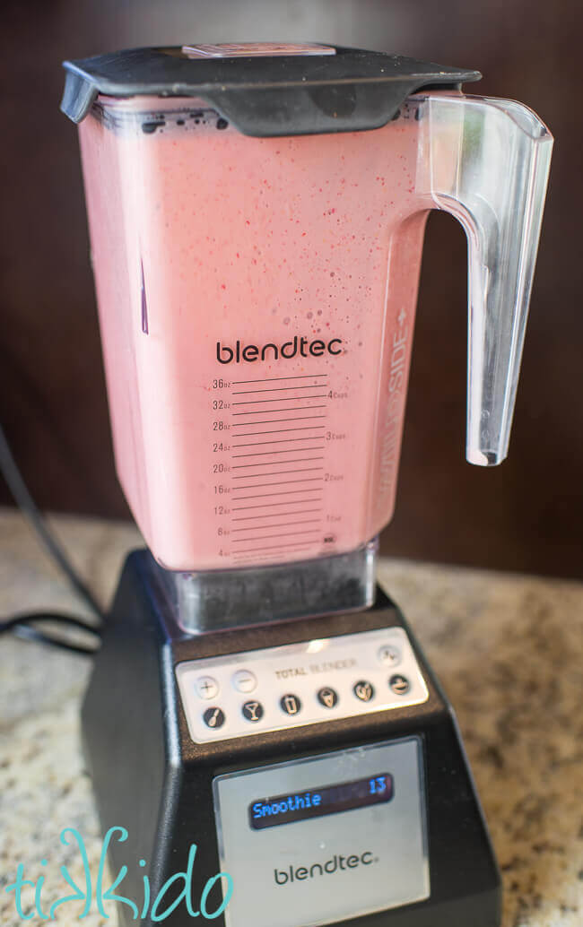 Buttermilk and strawberries being blended in a blendtec blender.