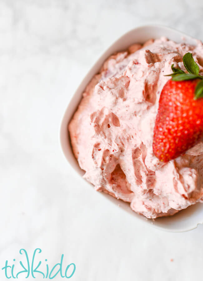 Bowl of Strawberry Whipped Cream topped with a fresh strawberry.