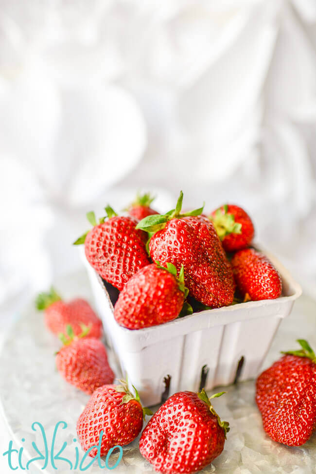 Basket of fresh strawberries on a white background.