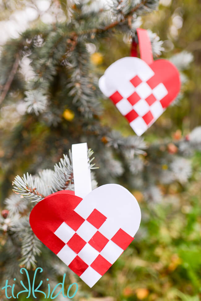 Two Swedish Paper Heart ornaments hanging in a Christmas tree.
