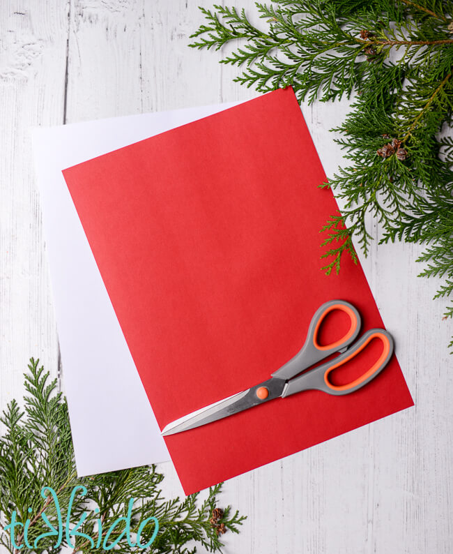 Red and white card stock and scissors for making Swedish Paper Hearts.