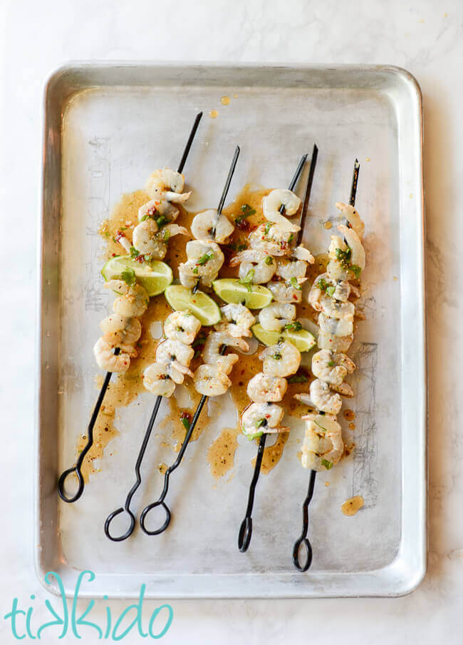 Skewers of tequila lime shrimp on a metal pan.