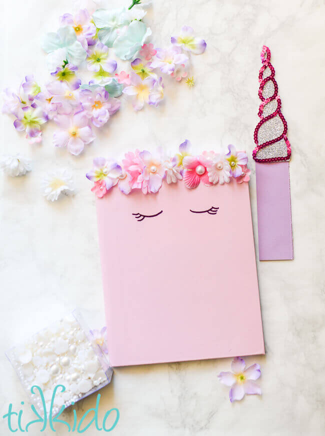Composition notebook decorated to look like a unicorn with a unicorn horn bookmark.