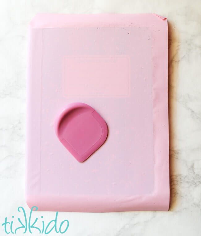 Composition notebook being covered in pink contact paper