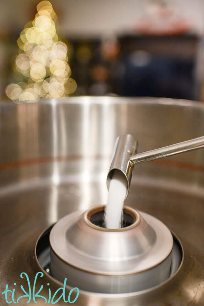 cotton candy being made in a cotton candy machine.