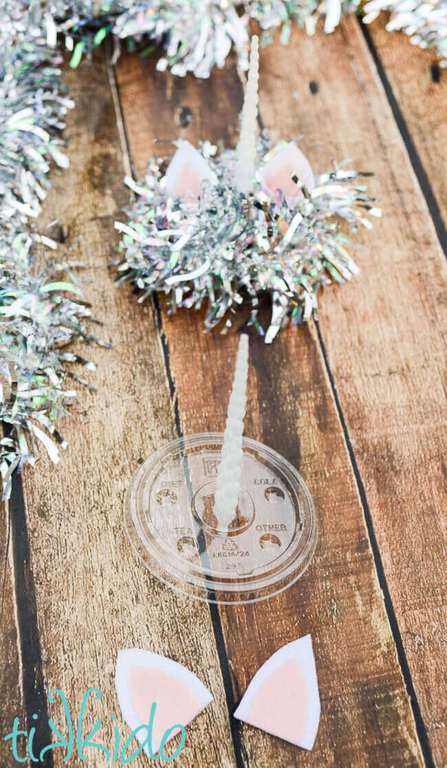 Making a unicorn cotton candy favor by decorating the lid of a plastic cup.