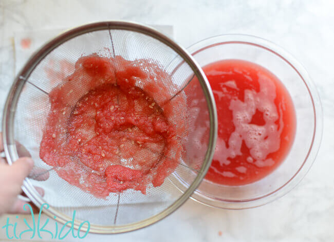 Blended watermelon being strained to remove the solids.