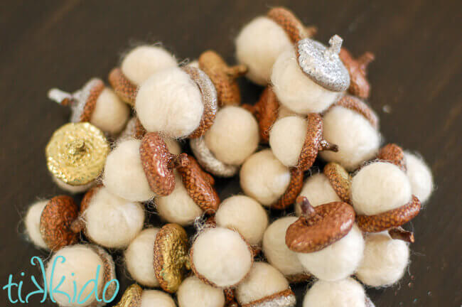 white felt acorns made with real acorn caps painted in metallic colors.