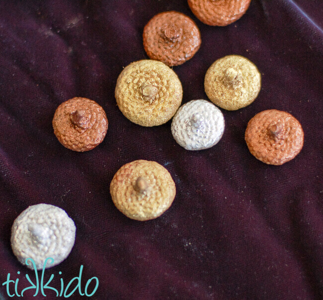 Acorn caps painted with gold, silver, and copper metallic spray paint.