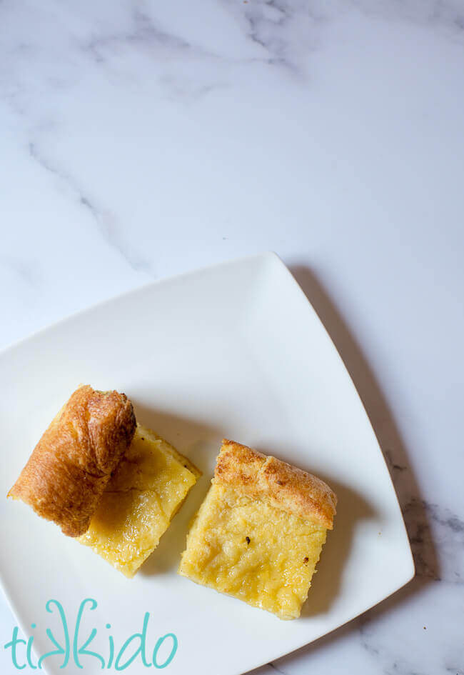 Pieces of Yorkshire pudding on a white plate on a white marble background.