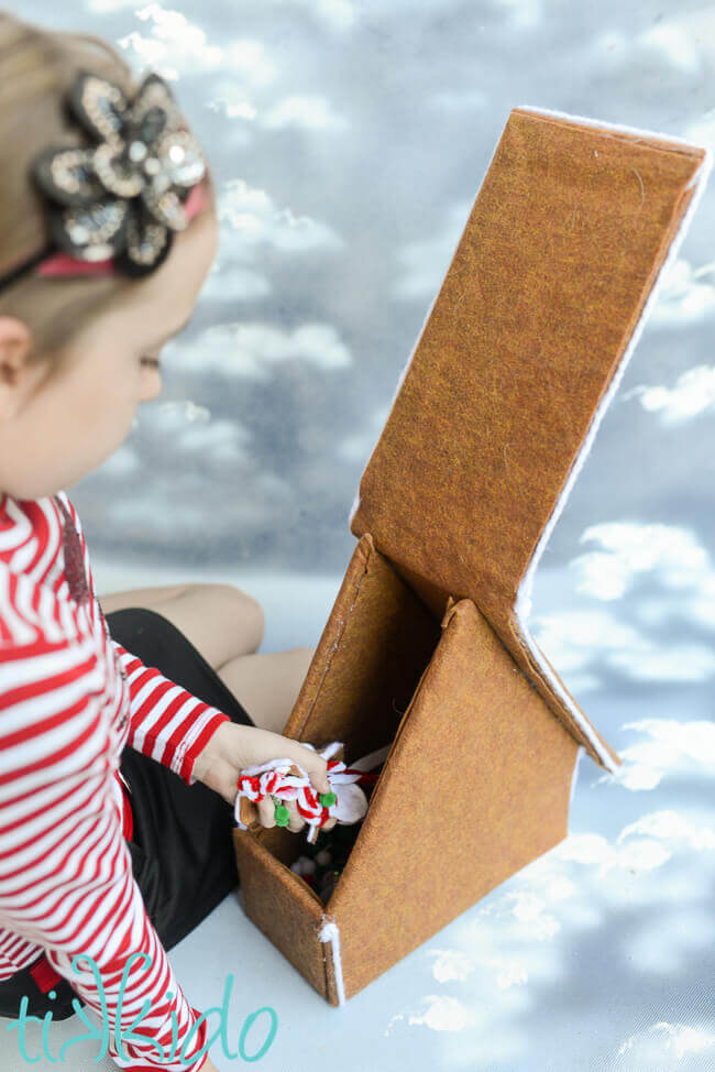 Little girl getting decorations out of a Felt Gingerbread House.