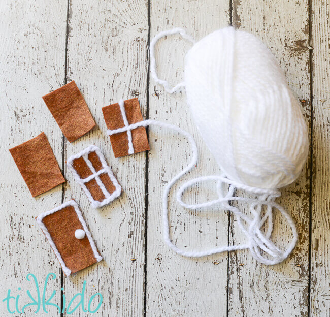 Decorative doors and windows for the Felt Gingerbread House being made out of white yarn and brown felt.