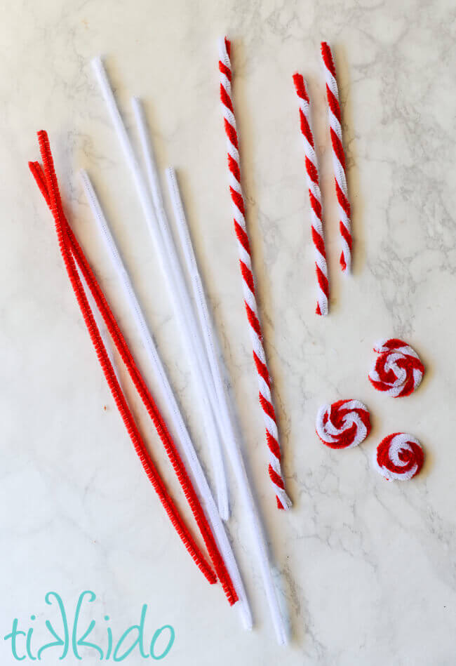 Fake red and white peppermint candies being made out of pipe cleaners for the Felt Gingerbread House.