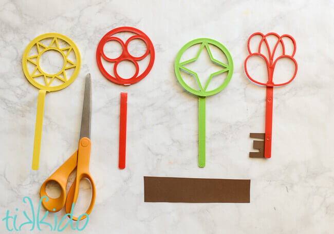 Colorful plastic bubble wands being cut and glued  into key shapes.