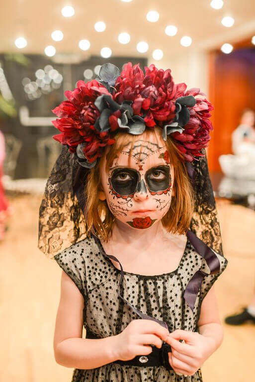 Little girl wearing a Day of the Dead headpiece with a veil