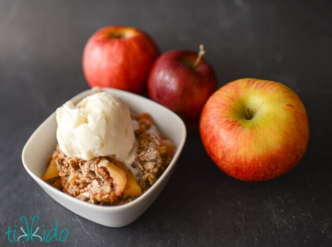 Bowl of apple crisp topped with vanilla ice cream