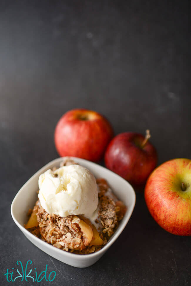 Bowl of apple crisp topped with vanilla ice cream