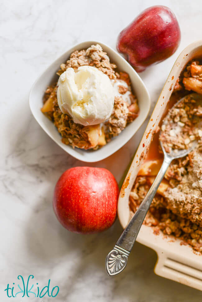 Bowl of apple crisp topped with vanilla ice cream