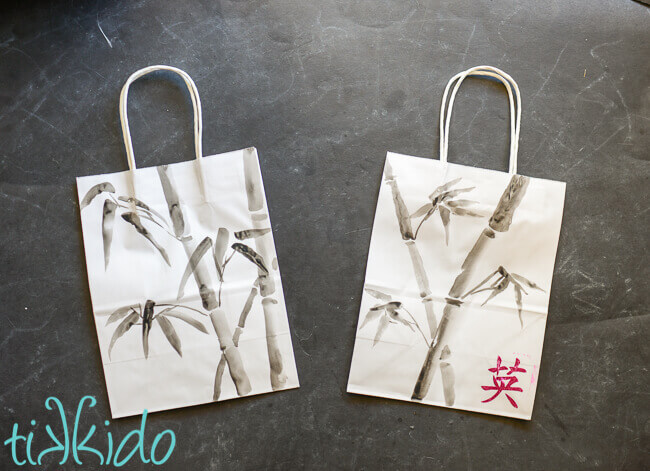 Two bamboo painted gift bags made with Japanese ink painting techniques, on a black chalkboard background.