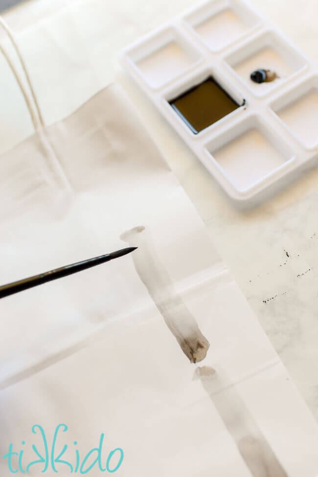 Japanese ink painting bamboo being painted on a plain white gift bag.