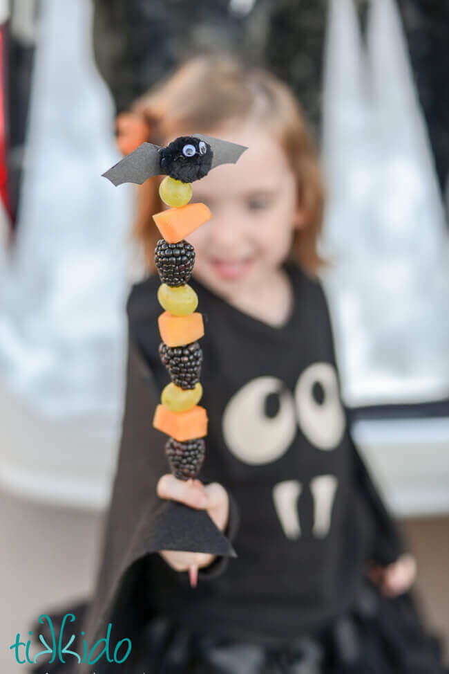 Healthy Halloween fruit skewer topped with a cute little bat.