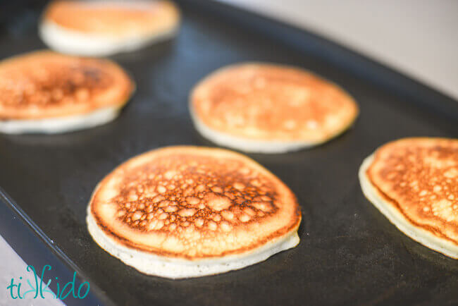 Birthday Cake Pancakes being cooked on an electric griddle.