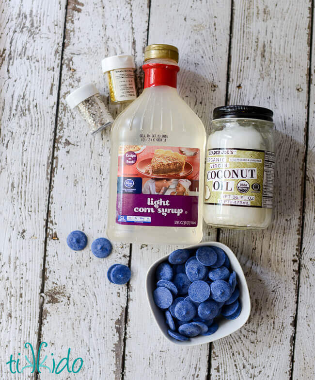 Ingredients for blue magic shell ice cream topping on a white weathered wooden surface.