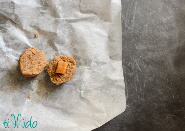 Ball of cookie dough being filled with caramel to make caramel latte cookies.