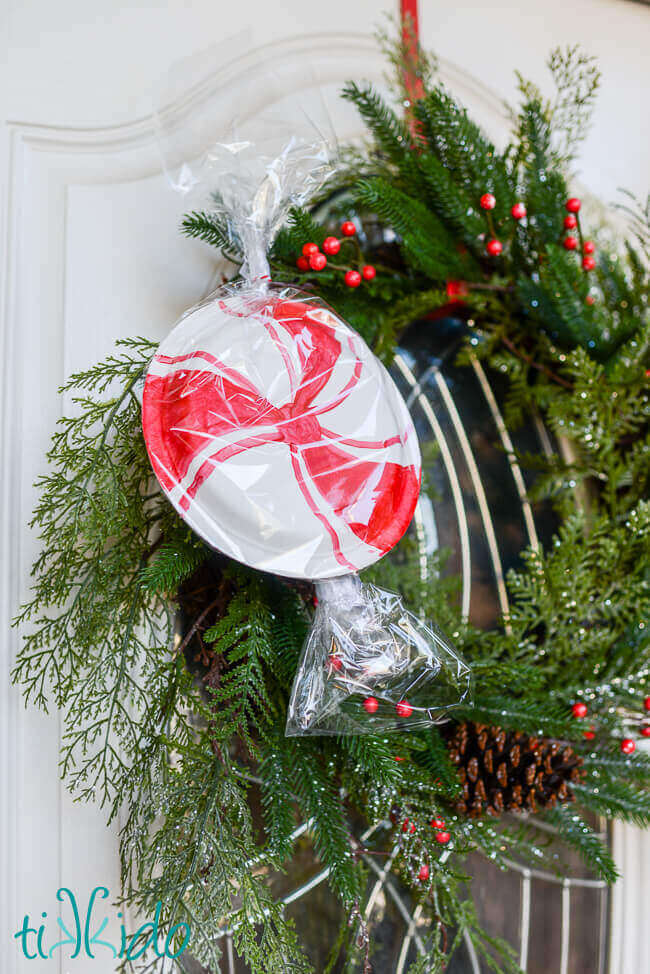 Easy, inexpensive, large scale peppermint decorations for Christmas made from paper plates decorating a wreath