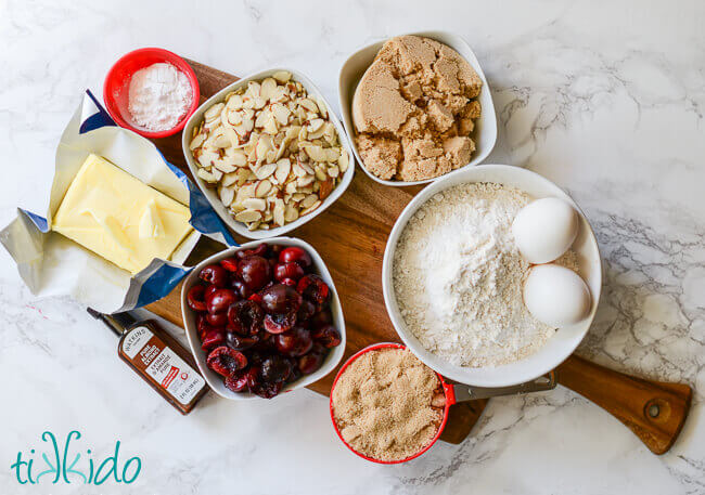 Ingredients for Cherry Almond Bar Cookies on a wooden cutting board.