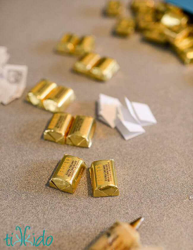 Gluing chocolates together to make chocolate book favors for a book themed party.