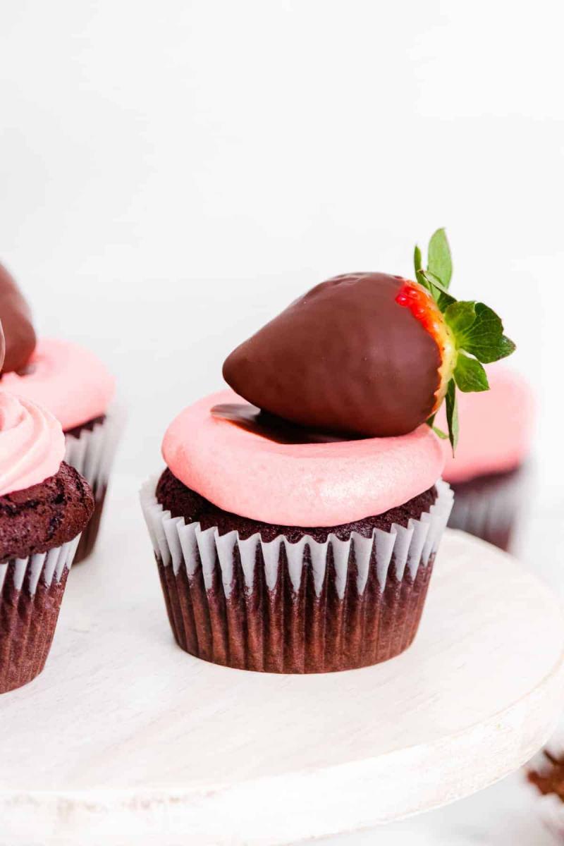Chocolate covered strawberry cupcake on a white plate.
