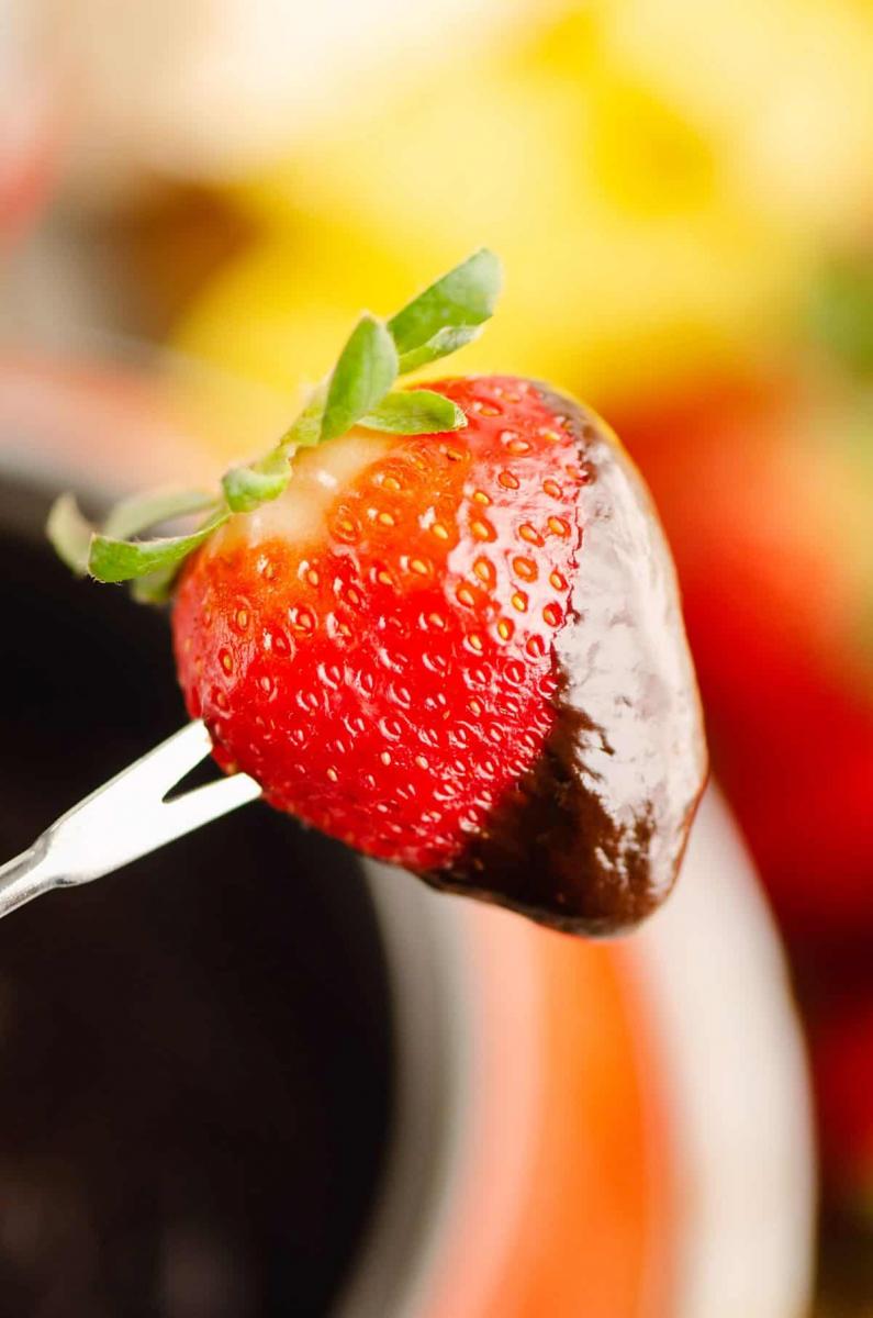 Strawberry dipped in chocolate fondue for Chocolate Covered Strawberry Valentine's Ideas Roundup.