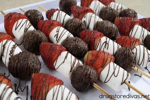 Easy strawberry chocolate and marshmallow dessert kabobs on a white plate.