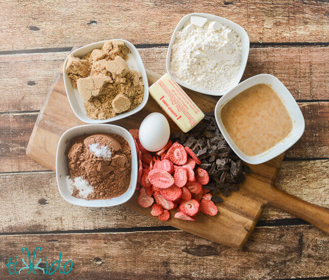 Ingredients for chocolate covered strawberry cookies arranged on a wooden cutting board.