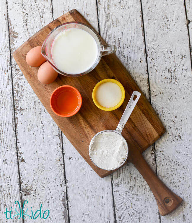 Ingredients for French crepes on a wooden cutting board.