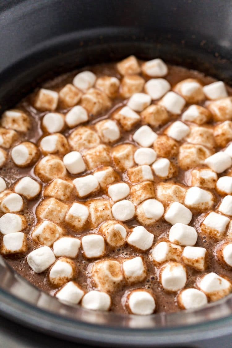 Slow cooker hot chocolate in a crock pot, topped with mini marshmallows.