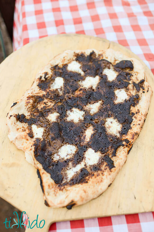Nutella, mascarpone, and brown sugar Chocolate dessert pizza on a wooden peel on a red checkered tablecloth
