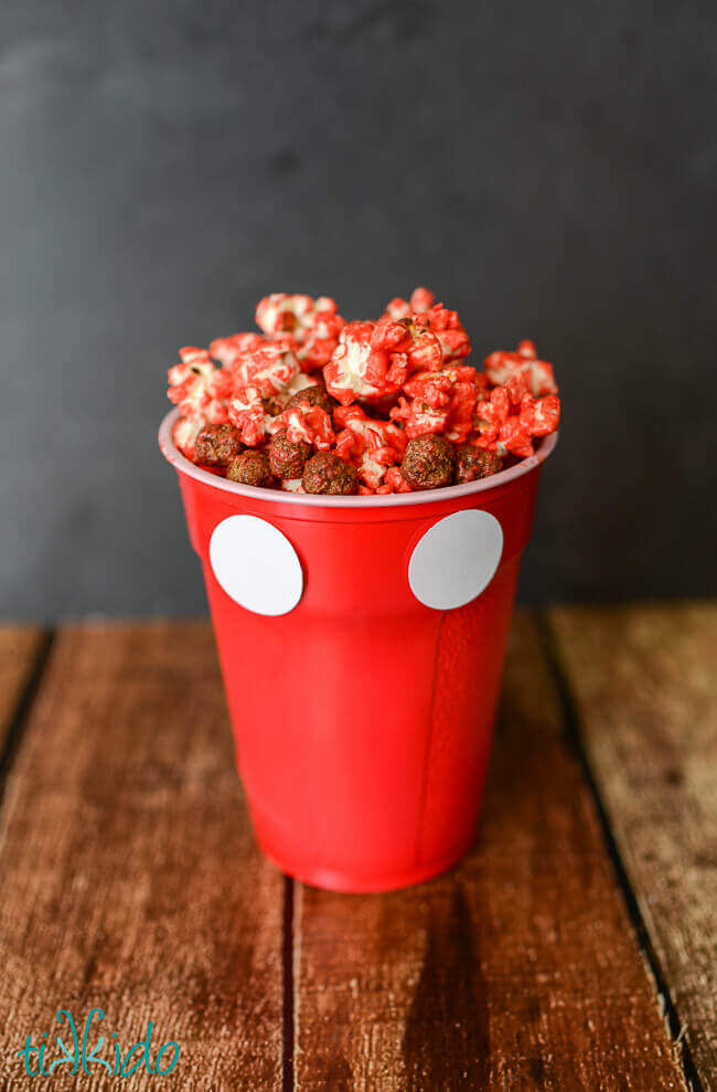 Mickey Mouse Polka Dot Popcorn in a Mickey Mouse cup on a dark background.