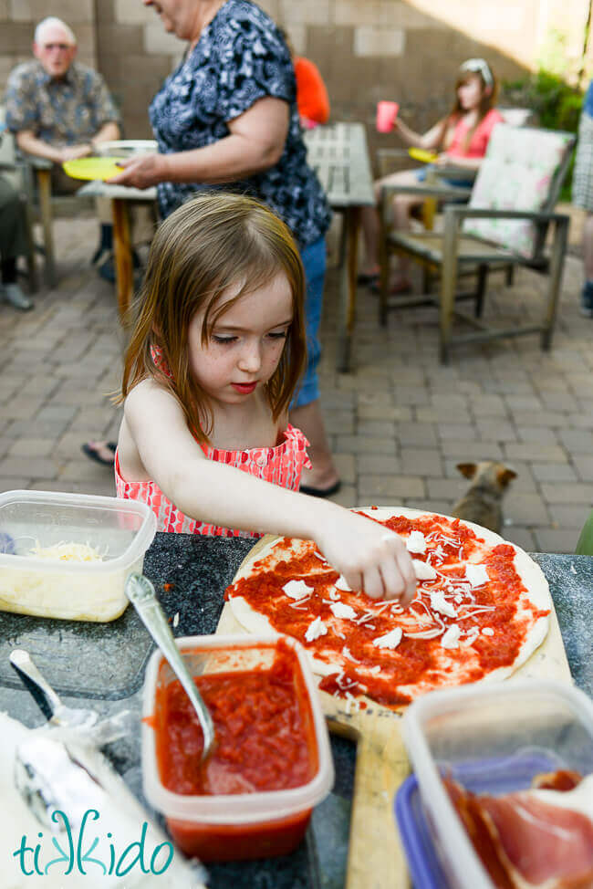 Child making pizza for a wood fired pizza oven.