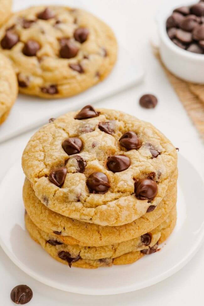 Stack of eggless chocolate chip cookies on a white napkin.